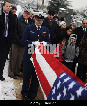 Petty Officer 2. Klasse Joseph Devito faltet die amerikanische Flagge, bevor es an die Familie von Seymour Wittek dargestellt wird Stockfoto