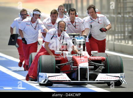 Toyota Mechaniker drücken Sie das Auto des deutschen Formel1-Fahrer Timo Glock am Ende im dritten Training auf dem Bahrain International Circuit, Sakhir, Bahrain, 25. April 2009. Ersten Platz Deutsche Formel1-Fahrer Timo Glock von Toyota in der Sitzung gefolgt von brasilianischen Formel1-Fahrer Felipe Massa von Ferrari in den zweiten Platz und deutschen Formel1-Fahrer Nico Rosberg von Stockfoto