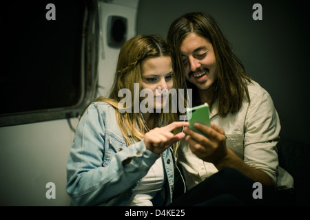 Paar, die Kopfhörer im Trailer anhören Stockfoto
