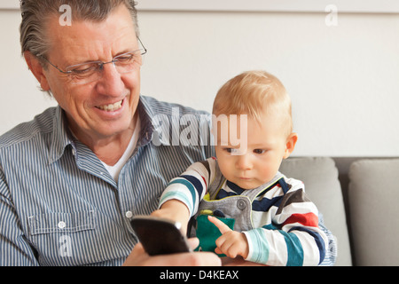 Mann mit Enkel mit Handy Stockfoto
