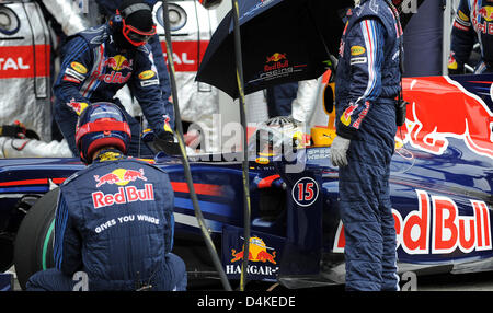 Deutsche Formel1-Fahrer Sebastian Vettel von Red Bull sitzt unter einem Regenschirm bei einem Boxenstopp während dem Qualifying für den Grand Prix von Deutschland am Nürburgring in Nuerburg, Deutschland, 11. Juli 2009. Die Formel 1 Grand Prix von Deutschland statt findet am Sonntag 12. Juli. Foto: PETER STEFFEN Stockfoto