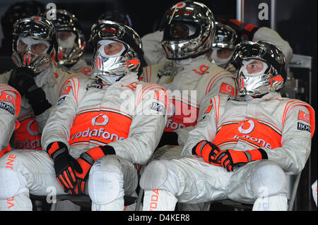 McLaren Mercedes Mechaniker sehen das Rennen auf einem Monitor in ihrer Garage während der Grand Prix von Deutschland auf dem Nürburgring in Nuerburg, Deutschland, 12. Juli 2009. Foto: PETER STEFFEN Stockfoto