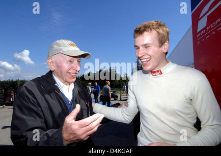 Britische Formel zwei Fahrer Henry Surtees von Barber Motorsports Team (R) lacht mit seinem Vater, der ehemalige Formel1 Weltmeister John Surtees beim Formel-2-Rennen in Brno, Tschechische Republik, 21. Juni 2009. 18-Year-Old Henry Surtees starb bei einem tragischen Unfall in der Formel 2 Rennen in Brands Hatch, Großbritannien am 19. Juli 2009. Surtees war durch eine lose Rennwagen Ty auf den Kopf getroffen. Stockfoto