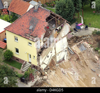 Blick auf die verbleibende Hälfte eines Hauses nach dem andern durch einen Erdrutsch in Nachterstedt, Deutschland, 20. Juli 2009 verschluckt wurde. Drei Bewohner fehlen nach ihrer Heimat am See und ein weiteres Gebäude stürzte plötzlich ins Wasser am 18. Juli. Ein 350 m langen Küstenlinie wich neben einem alten Tagebau Kohlemine umgewandelt zu einem See. Zwei Tage nach der Katastrophe, Experten di Stockfoto