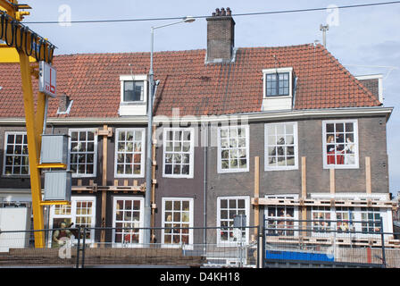 Evakuiert und eingezäunten Weg Häuser sind neben einer unterirdischen Baustelle in der Innenstadt von Amsterdam, Niederlande, 21. Juli 2009 abgebildet. Der Bau der neuen u-Bahnlinie in Amsterdam wurde der Anlass zur Sorge. Wasser hält durchbrechen, mehrere Häuser entlang der 10 km lange unterirdische Linie sank und mussten evakuiert werden. So weit, die Kosten für die Gebäude-hav Stockfoto