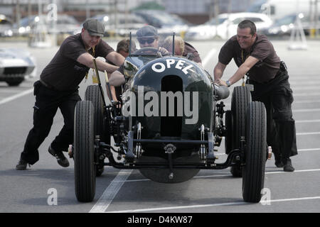 Eine Gruppe von Fans von Oldtimern schiebt einen alten Opel Rennwagen auf dem Gelände des Opel-Werks in Rüsselsheim, Deutschland, 22. Mai 2009. Angesichts der drohenden Insolvenz von uns Muttergesellschaft General Motors wollen Opel-Mitarbeiter der deutsche Automobilhersteller Liquiditätssicherung durch den Verzicht auf ihr Gehalt. Das Personal im Stammwerk Rüsselsheim und der Test Center in Stockfoto