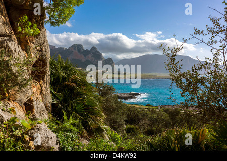 Frühling grün, felsige Landschaft blaue Meer und Ferne Berge, Cumulus-Wolken, San Vito lo Capo, Sizilien Stockfoto