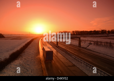 Verkehr fahren durch winterlichen Bedingungen bei Sonnenaufgang auf a1/m Autobahn in der Nähe von Leeds Yorkshire uk Stockfoto