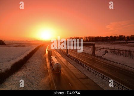 Verkehr fahren durch winterlichen Bedingungen bei Sonnenaufgang auf a1/m Autobahn in der Nähe von Leeds Yorkshire uk Stockfoto