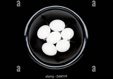 Weißen Eiern in schwarz Schüssel Stockfoto
