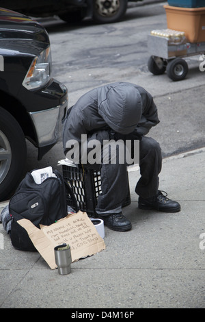 Obdachloser Betteln auf der Straße entlang der 5th Avenue in New York City. Stockfoto