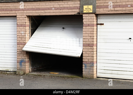 Eine abschließbare Garage mit einer defekten Tür, UK Stockfoto