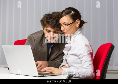 Zwei glückliche Geschäftspartnern zusammenarbeiten auf Laptop in ihrem Büro. Stockfoto