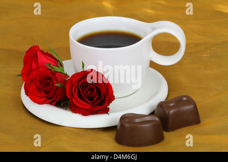 Tasse Kaffee, rote Rosen und milchige Schokolade Stockfoto