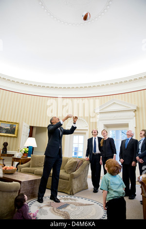 US Präsident Barack Obama wirft einen Basketball in der Luft während der Abfahrt Fotos mit Samantha J. Power, Senior Direktor für multilaterale Angelegenheiten und Menschenrechte und ihre Familie im Oval Office 22. Februar 2013 in Washington, DC. Beobachten den Präsidenten, von links, sind: Rian Power-Sunstein, Cass Sunstein, Samatha Power, Declan Sunstein, James Bourke und Veronica Delany. Stockfoto