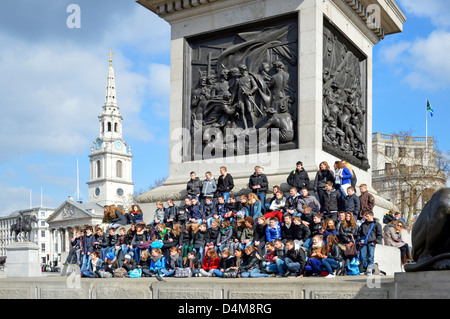 Schulbesuch in London für die große Gruppe von Kindern posieren für Gruppenfoto auf Nelsons Säule Sockel Stockfoto