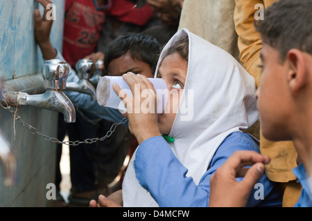 Usman Kurea trinken, Pakistan, Kinder aus einem Trinkwasser-Behälter Stockfoto