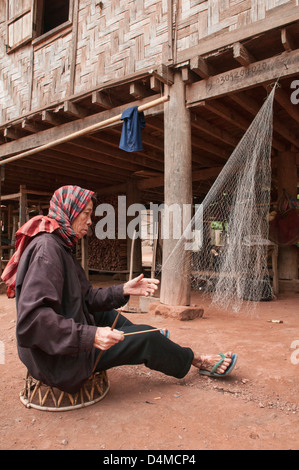 ethnische Khmu Mann seine Fischerei ausbessern Netze, Luang Nam Tha, Laos Stockfoto