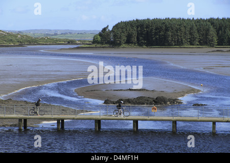 Radfahrer beim Überqueren einer Brücke über die Mündung des Flusses bawnaknockane, ballydehob, West Cork, Republik von Irland Stockfoto