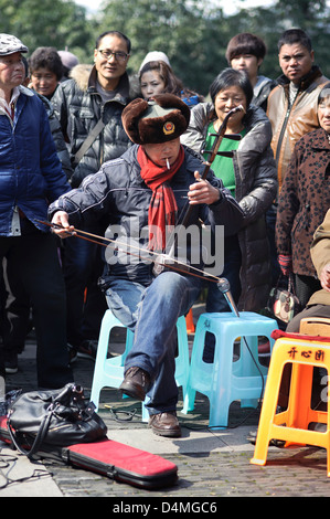 Ein Mann spielt die traditionelle chinesische stringed Instrument die Erhu neben Westsee in Hangzhou, China Stockfoto