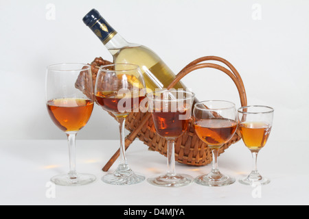 Flasche Weißwein in einzelnen Wein Weidenkorb mit teilweise Gläser gelb gefärbte Flüssigkeit gefüllt Stockfoto
