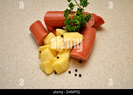 Petersilie auf rohe Kielbasa und Kartoffeln Stockfoto