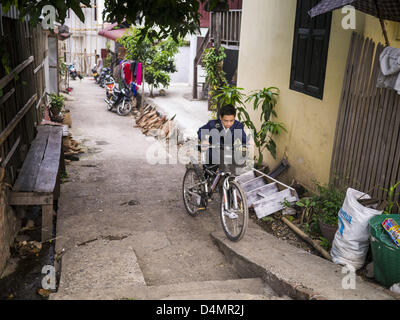 11. März 2013 - Luang Prabang, Luang Prabang, Laos - ein Junge auf dem Weg zur Schule schiebt sein Fahrrad auf einer engen Gasse in Luang Prabang, Laos. (Bild Kredit: Jack Kurtz/ZUMAPRESS.com ©) Stockfoto