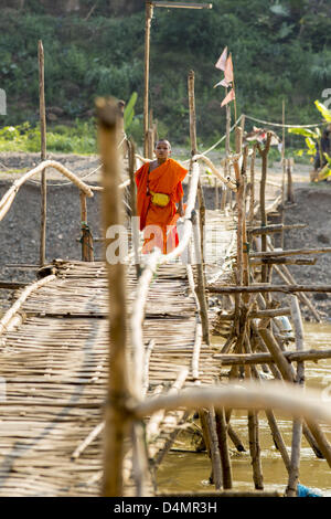 11. März 2013 - Luang Prabang, Luang Prabang, herüber Nam Khan Fluss in Luang Prabang Laos - A buddhistische Anfänger auf der Fussgängerbrücke Bambus. Die Bridge ist eine saisonale. Es wird erstellt, wenn der Pegelstand in der Trockenzeit tritt und jedes Jahr spült, wenn der Fluss entspringt. Er verbindet mehrere kleine Dörfer nördlich der Stadt Luang Prabang. (Bild Kredit: Jack Kurtz/ZUMAPRESS.com ©) Stockfoto