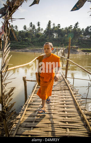 11. März 2013 - Luang Prabang, Luang Prabang, herüber Nam Khan Fluss in Luang Prabang Laos - A buddhistische Anfänger auf der Fussgängerbrücke Bambus. Die Bridge ist eine saisonale. Es wird erstellt, wenn der Pegelstand in der Trockenzeit tritt und jedes Jahr spült, wenn der Fluss entspringt. Er verbindet mehrere kleine Dörfer nördlich der Stadt Luang Prabang. (Bild Kredit: Jack Kurtz/ZUMAPRESS.com ©) Stockfoto