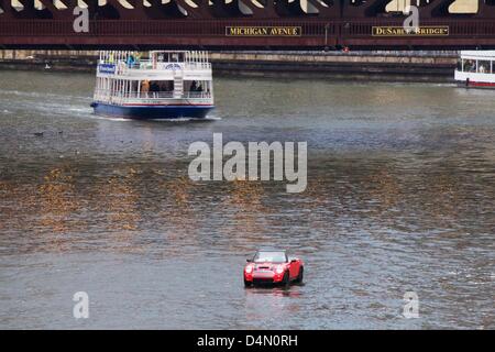 Chicago, Illinois, USA, 16. März 2013. Ein schwimmendes Mini Cooper lagen den Chicago River vor dem Fluss wird für den St. Patricks Day Feier grün gefärbt. Das Handwerk ist eigentlich eine Fiberglas Form eines Mini platziert auf einem kleinen Boot. Bildnachweis: Todd Bannor / Alamy Live News Stockfoto