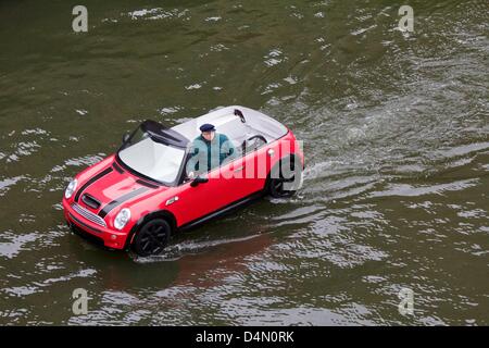 Chicago, Illinois, USA, 16. März 2013. Ein schwimmendes Mini Cooper lagen den Chicago River vor dem Fluss wird für den St. Patricks Day Feier grün gefärbt. Das Handwerk ist eigentlich eine Fiberglas Form eines Mini platziert auf einem kleinen Boot. Bildnachweis: Todd Bannor / Alamy Live News Stockfoto