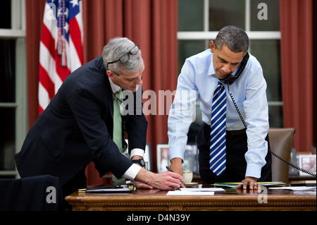 US-Präsident Barack Obama mit Stabschef Denis McDonough verleiht, wie er am Telefon mit Senator Carl Levin aus dem Oval Office 6. Februar 2013 in Washington, DC spricht. Stockfoto