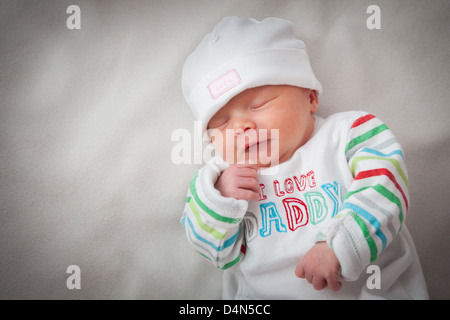 Baby Mädchen (8 Tage alt) in ein sehr weiches Licht (ein leichtes Zelt) genommen. Hut zu lesen'süß' und oben liest "I love Daddy". Stockfoto