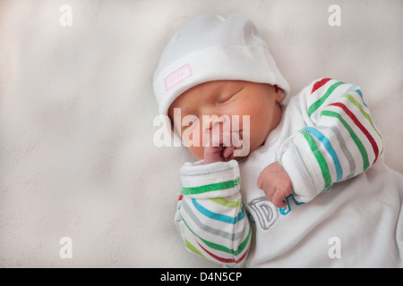 Schöne Mädchen (8 Tage alt) hielt ihre Hände. Ein sehr weiches Licht aufgenommen. Hut liest'süß' und oben liest "I love Daddy". Stockfoto