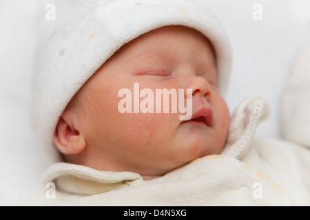 Schöne Neugeborenen schlafendes Baby Mädchen gehüllt in ein Vlies Body und Hut. In genau 2 Stunden alt genommen. Auge im Mittelpunkt. Stockfoto