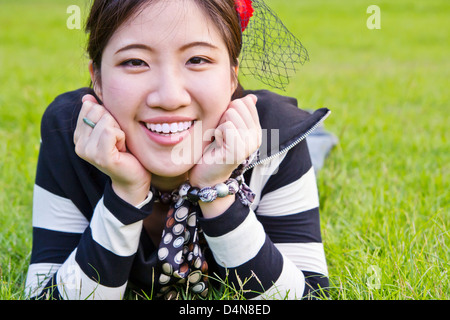 Asiatische Frau entspannen auf dem Rasen Stockfoto