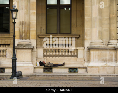 Mann schläft im Louvre in paris Stockfoto