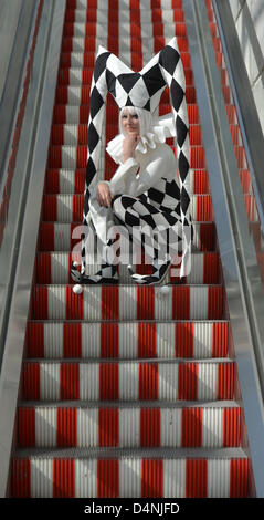 Eine Frau in einem Harlekin-Kleid ist auf elektrische Treppe auf der Buchmesse in Leipzig, Deutschland, 17. März 2013 abgebildet. Die Messe endet nach vier Tagen mit ca. 168,000 Besucher. Mehr als 2000 Verlage aus 43 Ländern präsentierten sich mit ihren Neuheiten auf der Messe. Foto: Hendrik Schmidt Stockfoto