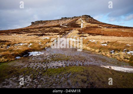 Am späten Nachmittag durchbricht Sonnenschein auf Higger Tor im Peak District den Weg in das Schmelzwasser getränkt wird. Stockfoto