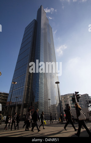 Fußgänger begeben sich während der morgendlichen Hauptverkehrszeit am Heron Tower am 110 Bishopsgate, London, UK, vorbei und zeigen den täglichen Pendlerverkehr durch eines der wichtigsten Geschäftsviertel der Stadt. Stockfoto