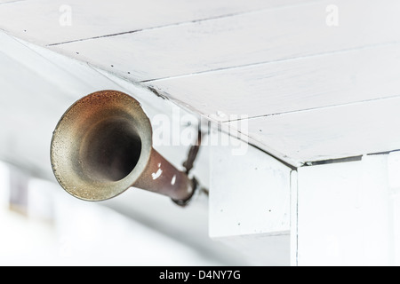 Nahaufnahme des alten Grunge Metall Horn auf Schiff unter alte weiße Holzdecke. Akustisches Signal bei Meer reisen. Weg von warnin Stockfoto