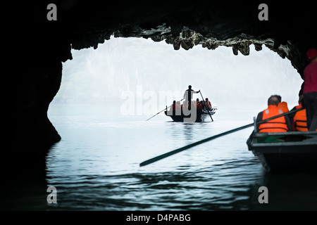 Boote mit Touristen in der Halong Bucht in Vietnam. Ein Boot im Vordergrund ein anderes im Hintergrund. Panoramablick vom dunklen Höhle. Stockfoto