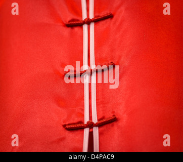 Nahaufnahme der traditionelle Kleidung in Vietnam. Detail des vietnamesischen Damenkleid. Leuchtend rote satin oder Seide Stoff mit weißen l Stockfoto