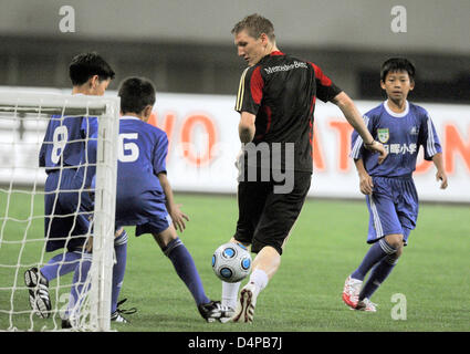 Deutsche Fußball spielt internationale Bastian Schweinsteiger (C) gegen ein chinesisches unter-12-Team in Shanghai, China, 27. Mai 2009. Die deutsche Nationalmannschaft ist auf einer Asientour, zwei Freundschaftsspiele, in Shanghai und in Dubai zu spielen. Foto: Marcus Brandt Stockfoto