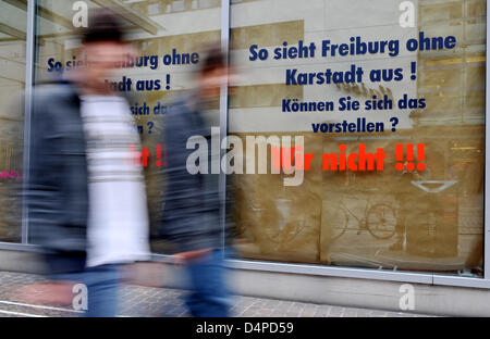 Zwei Männer gehen vorbei an eine verschleierte Schaufenster einer Karstadt-Filiale in Freiburg im Breisgau, 5. Juni 2009. Dadurch sollen Kunden sehen, wie die Front des Ladens aussehen würde wenn es geschlossen wurde. Der Betriebsrat und die Gewerkschaft ver.di will protestieren für staatliche Hilfe für das Speichern der Muttergesellschaft Arcandor mit Kampagnen wie diese nächste Woche. 32,000 Mitarbeiter sind von Sonntag ab c Stockfoto