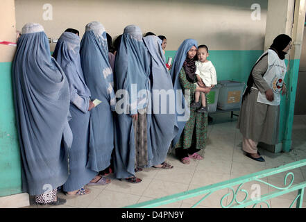 Afghanische Frauen halten ihre Stimmkarten während sie in einem Wahllokal in einer Moschee in Kabul, Afghanistan, 20. August 2009 warten. Es ist das zweite Mal, dass einige 12 Millionen Afghanen einen neuen Präsidenten nach der Zerstörung des Taliban-Regimes wahlberechtigt sind. Foto: Marcel Mettelsiefen Stockfoto