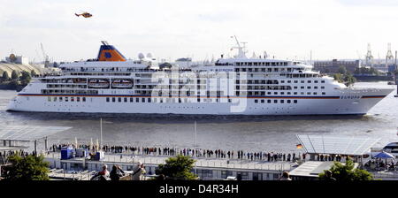 Ein Feuerwehr-Boot sprüht Brunnen neben Kreuzfahrtschiff? MS Europa? am Hafen in Hamburg, Deutschland, 21. September 2009. Ater zwei Wochen Renovierungsarbeiten das 200m lange Schiff seinen 10. Geburtstag mit einer kleinen feierte Kreuzfahrt auf dem Fluss Elbe. Bei der Gelegenheit? Berlitz Cruise Guide? dem Schiff seinen zehnten Mal in Folge verliehen? 5 Sterne Plus? Preis, eine noch nie dagewesene Leistung. Foto: Stockfoto