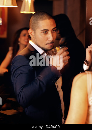 Porträt von einem Mann auf einer Party mit einem Glas Whisky Stockfoto