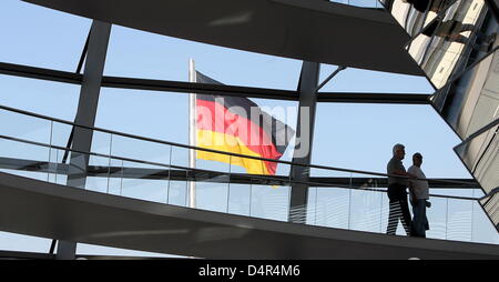 Touristen neben einer deutschen Nationalflagge in der Kuppel des Reichstagsgebäudes in Berlin, Deutschland, 27. September 2009. Foto: Alina Novopashina Stockfoto