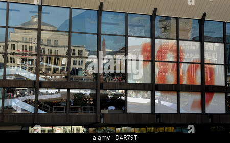 Ein Plakat lesen? 89? hängt hinter einer Glasfront in Leipzig, Deutschland, 9. Oktober 2009. Das Opernhaus und das Kroch-Hochhaus am Augustus-Platz spiegeln sich im Glas. Der Festakt zum 20. Jahrestag der friedlichen Revolution fand hier am Morgen. 9. Oktober 1989 gilt als Durchbruch der friedlichen Revolution. Damals gehen 70.000 Demonstranten Stockfoto